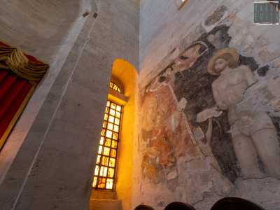 L�affresco sulla sinistra invece � del XIV secolo e rappresenta il martirio di San Sebastiano. Si distingue un soldato scagliare frecce contro il santo e, illuminata dalla finestra, la �Madonna con bambino�